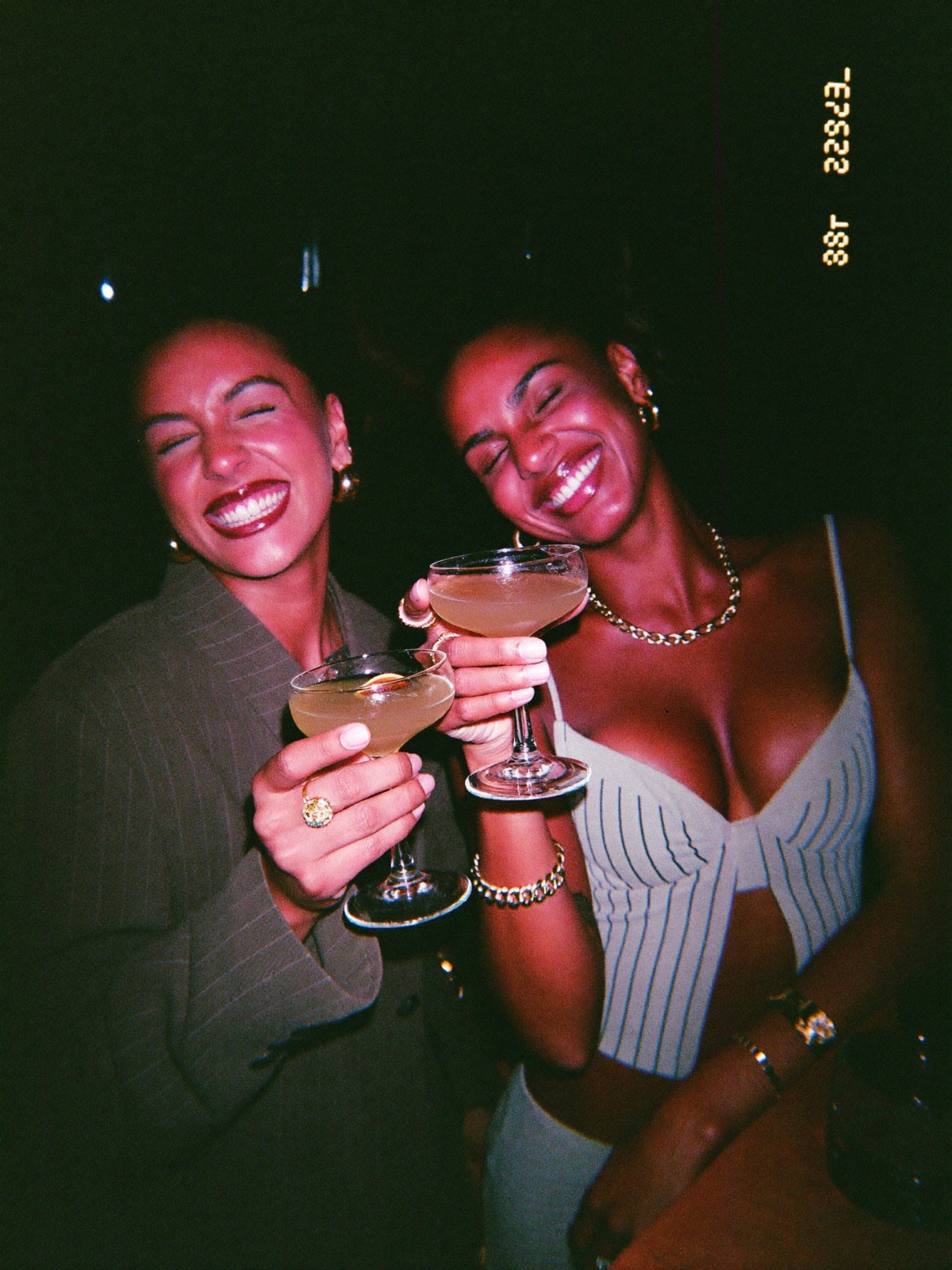 Two friends clinking cocktail glasses
