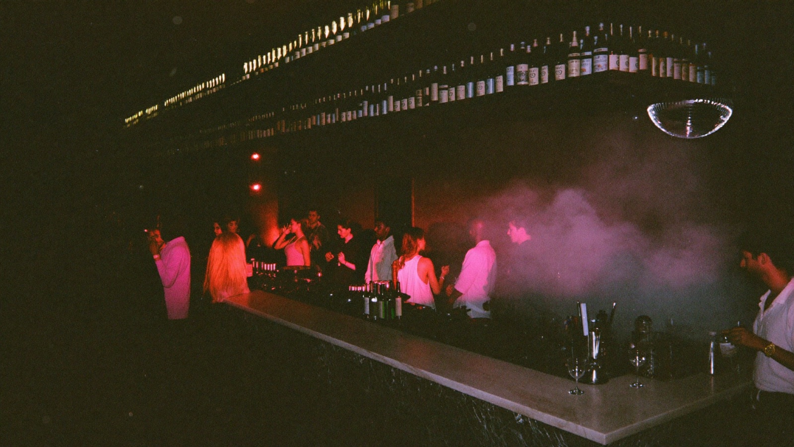 The main room at Superluna, packed, lit magenta and green
